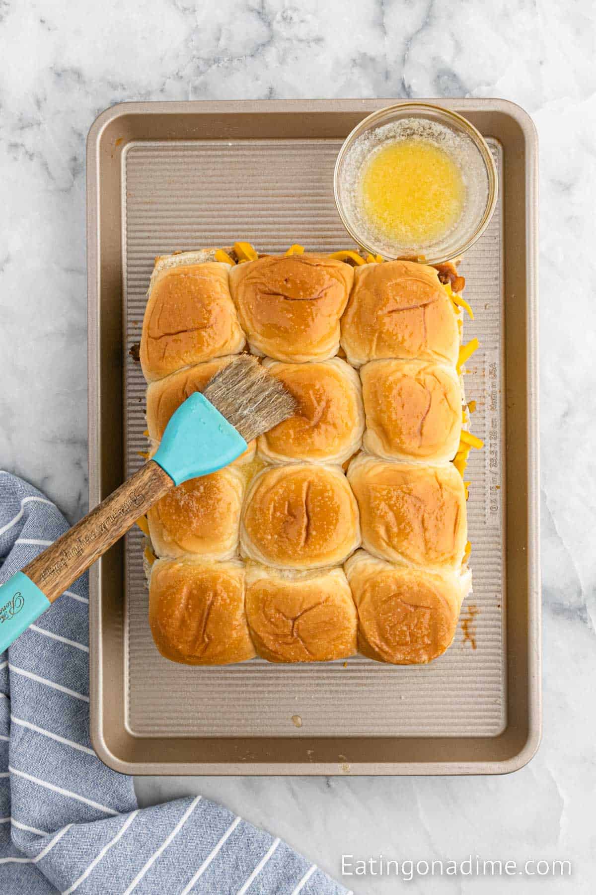 Topping the rolls with garlic butter with a brush