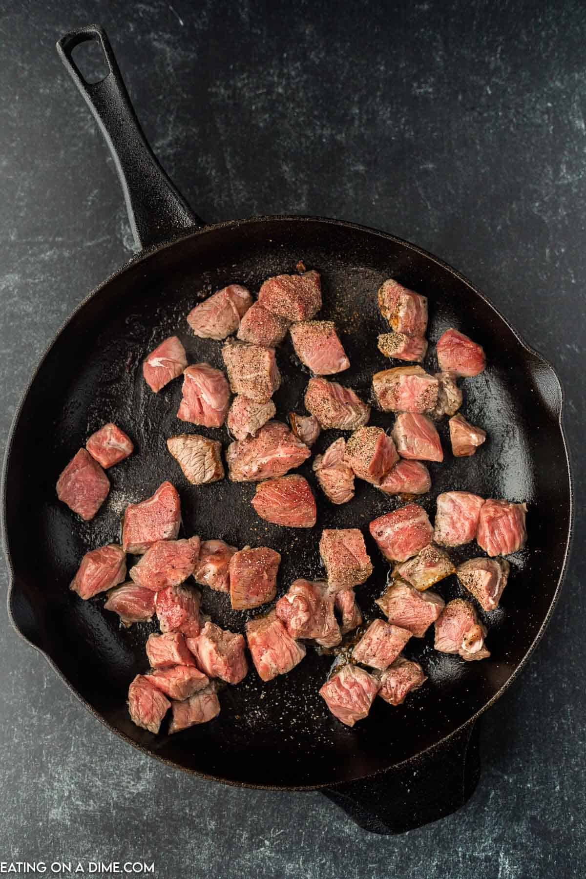 Placing steak bites in skillet