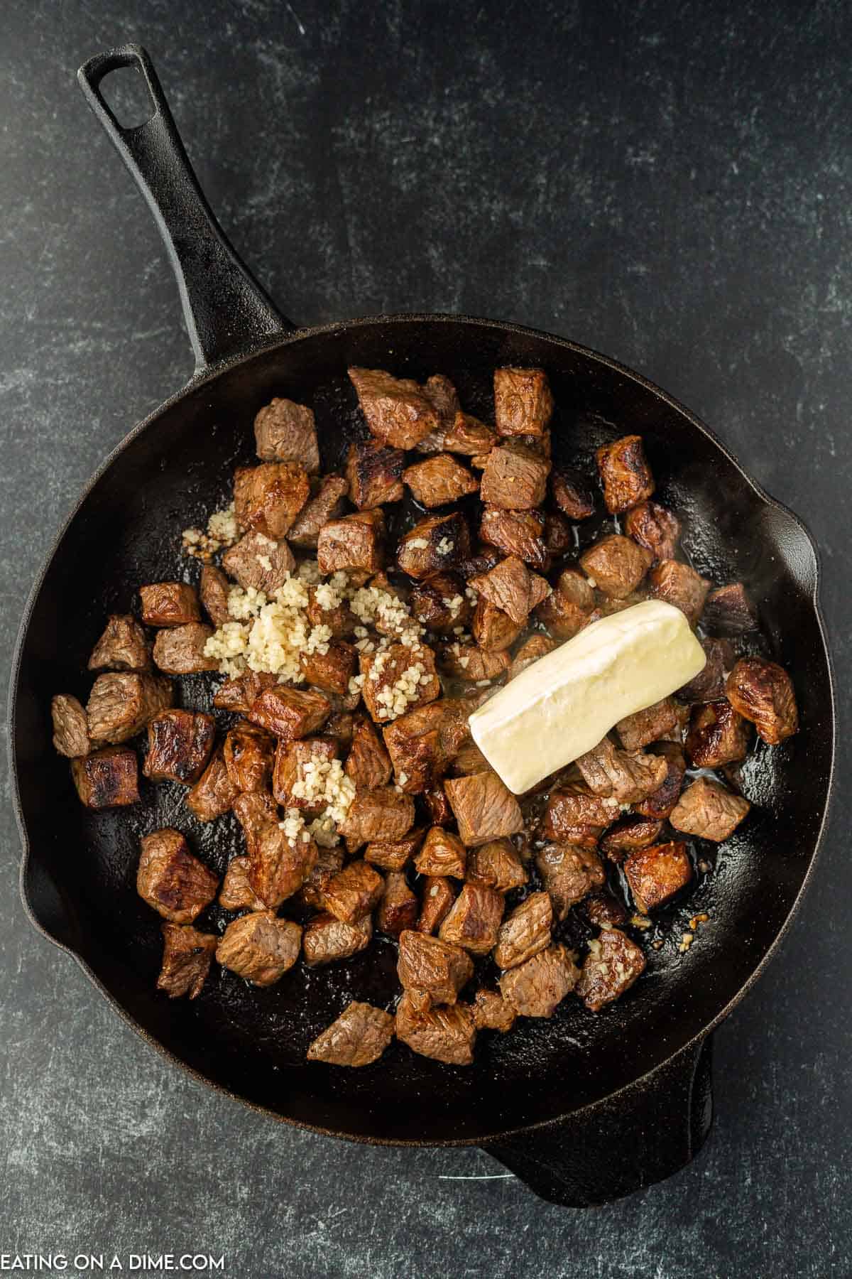 Topping cooked steak with butter and garlic