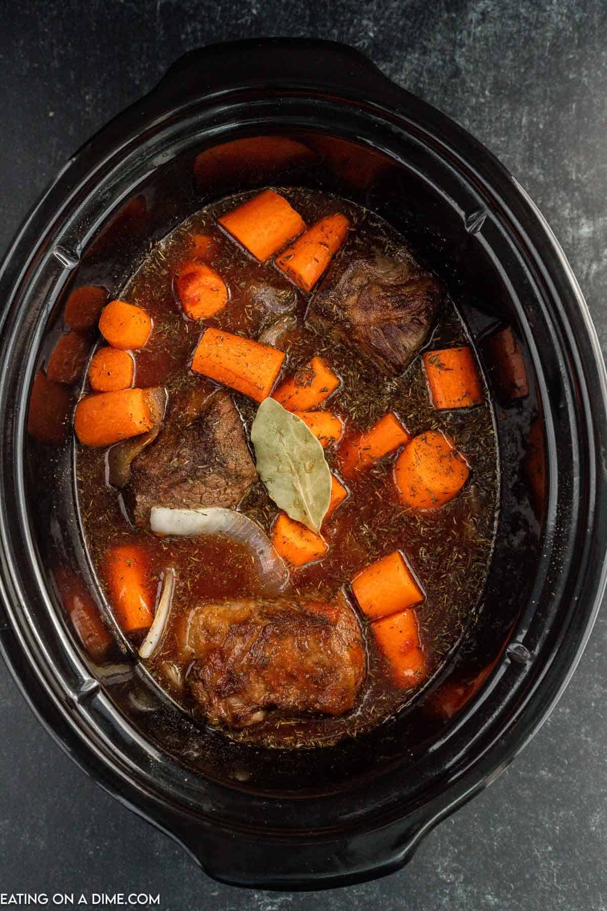 placing the cooked short ribs in the slow cooker with the remaining ingredients