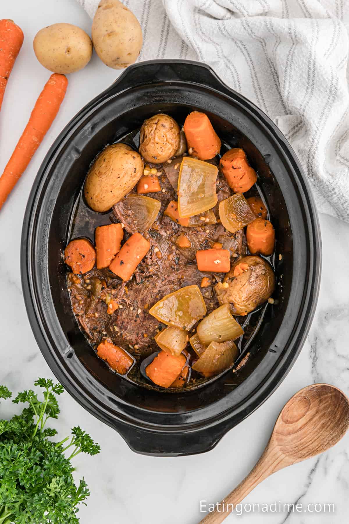 Cooked venison roast with carrots and potatoes in a slow cooker