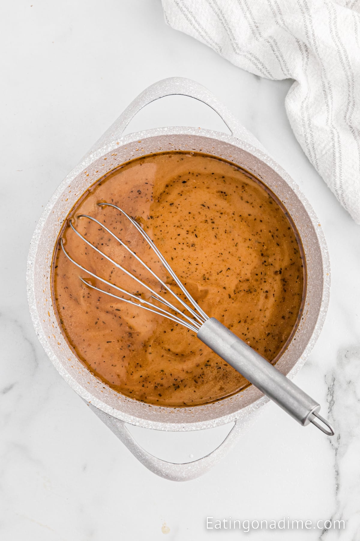 Cooking broth and gravy in a saucepan with a whisk
