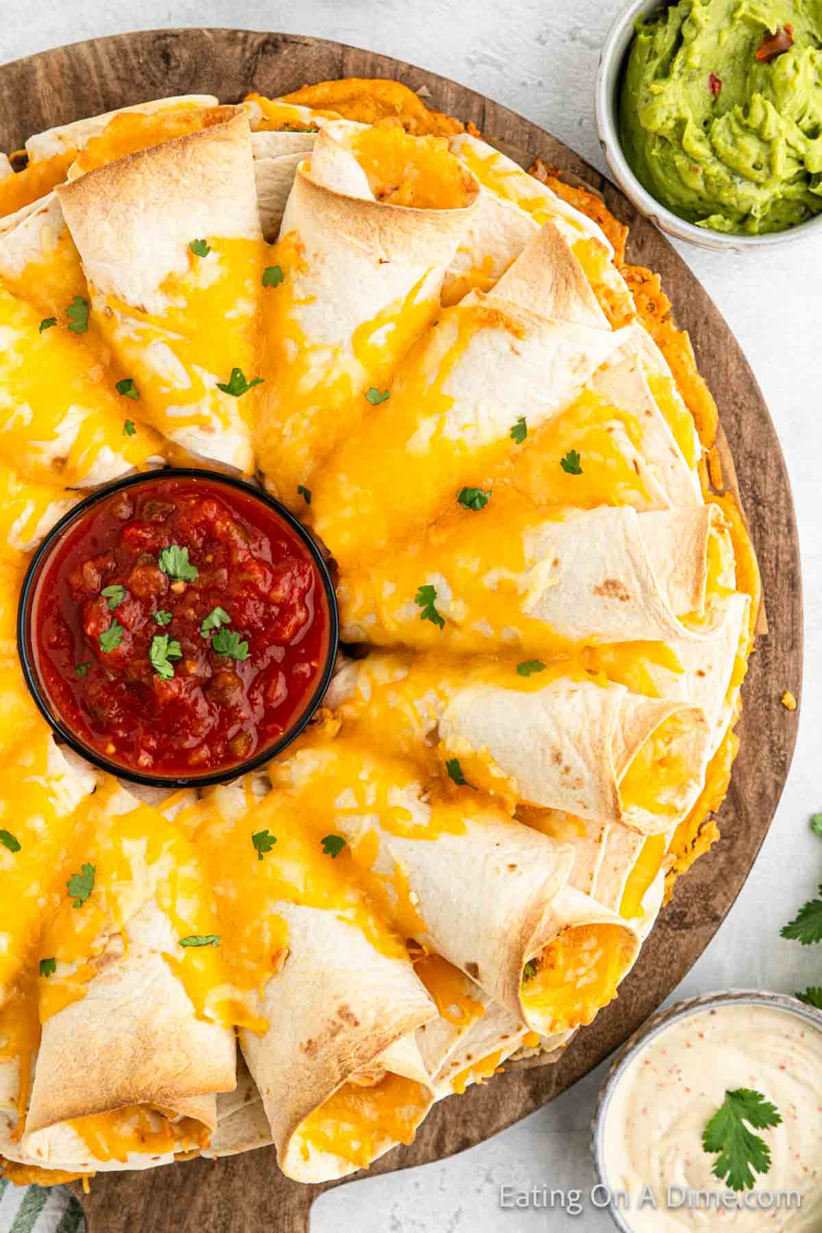 Blooming Quesadillas Ring on a wooden platter with a bowl of salsa in the center