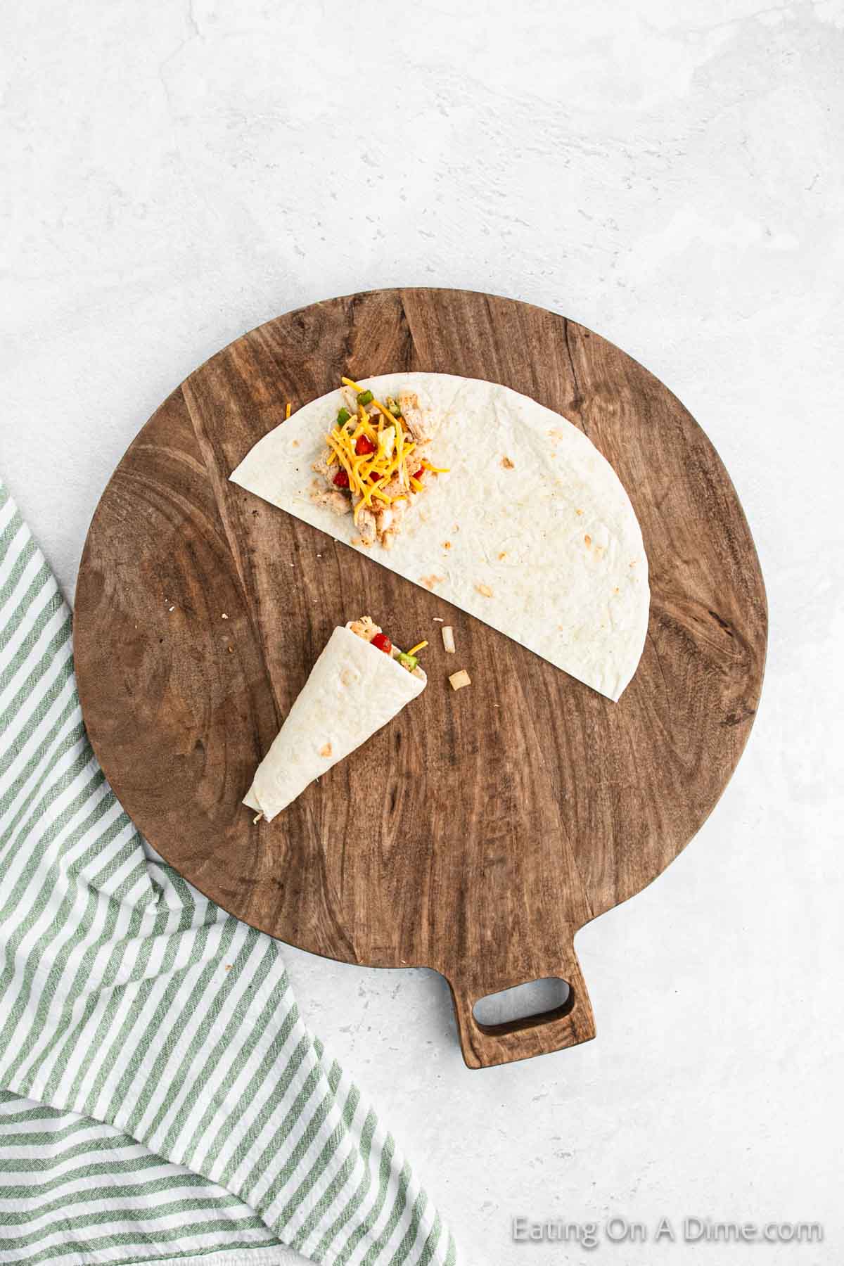 Topping flour tortillas with chicken mixture then rolling into corn shape