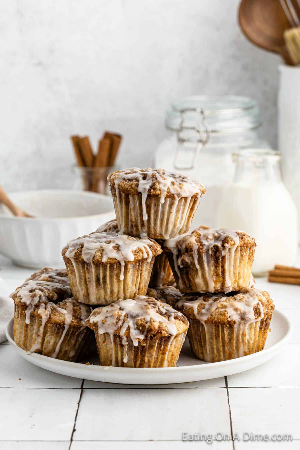 Cinnamon roll muffins topped with glaze stacked on a plate