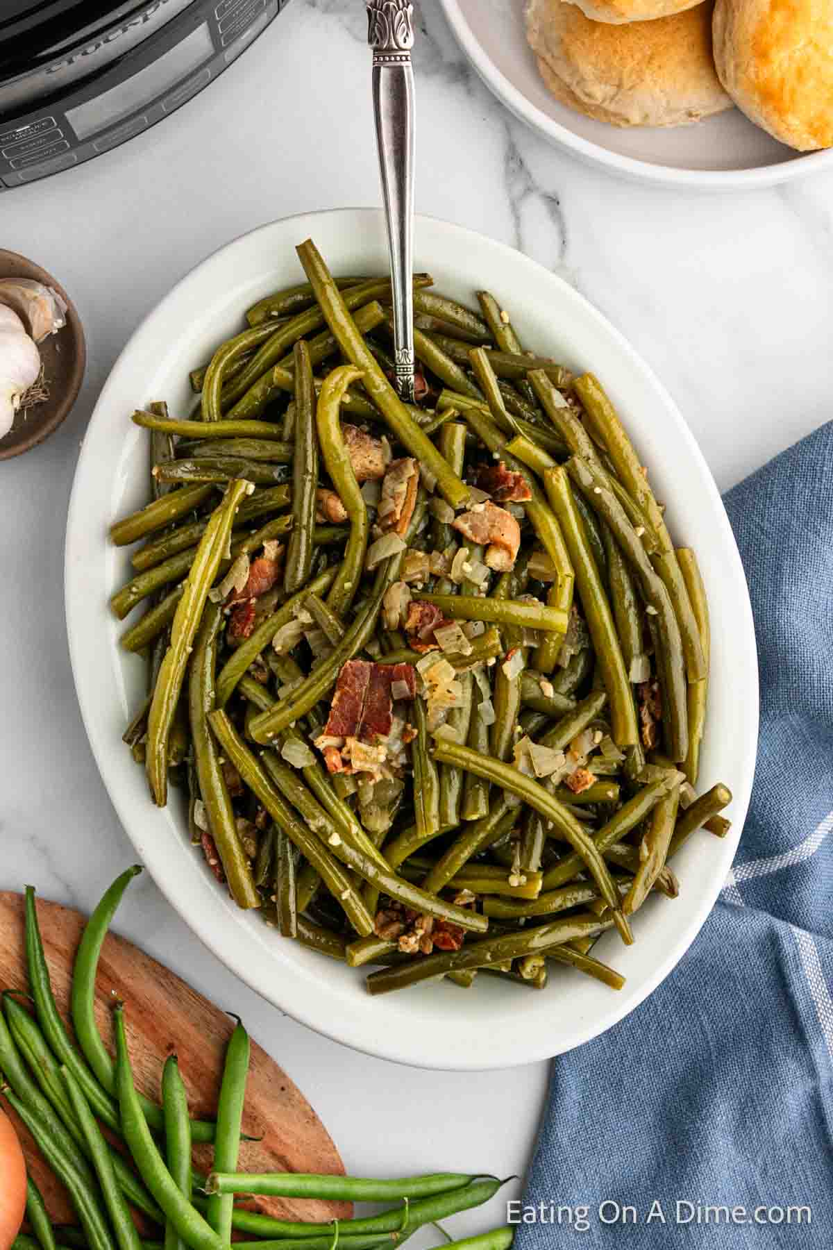 Green Beans on a platter topped with onions and bacon