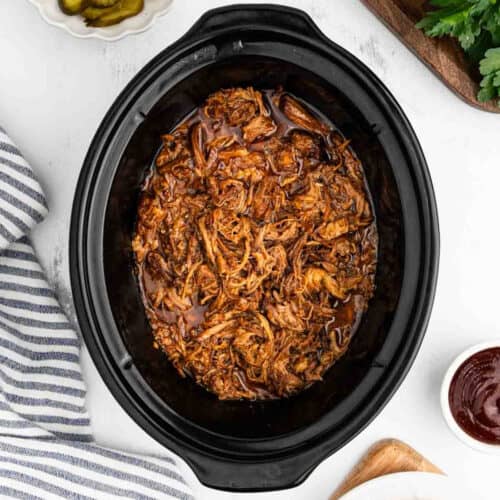 Shredded, juicy pulled pork in a crock pot.