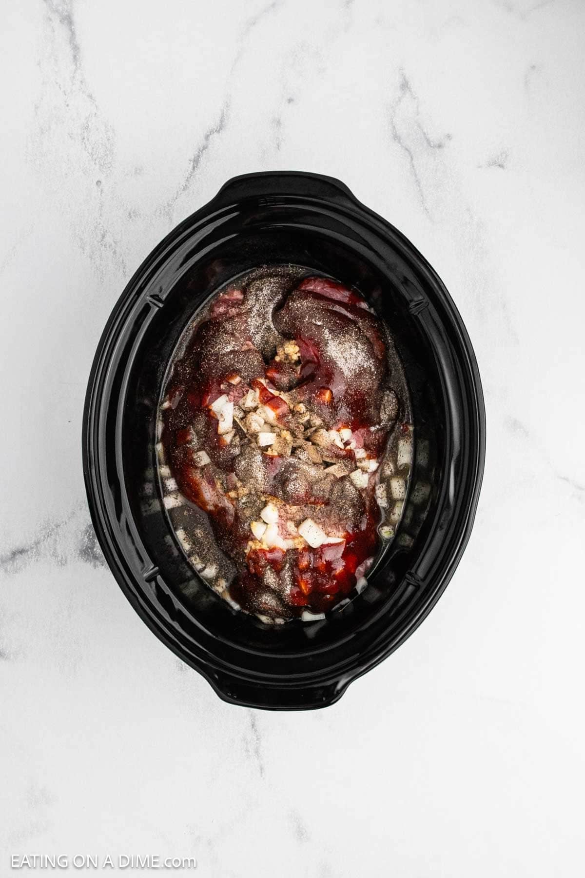 Ingredients are added to the crock pot to make this recipe.