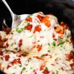 stuffed shells being pulled by a metal spatula.