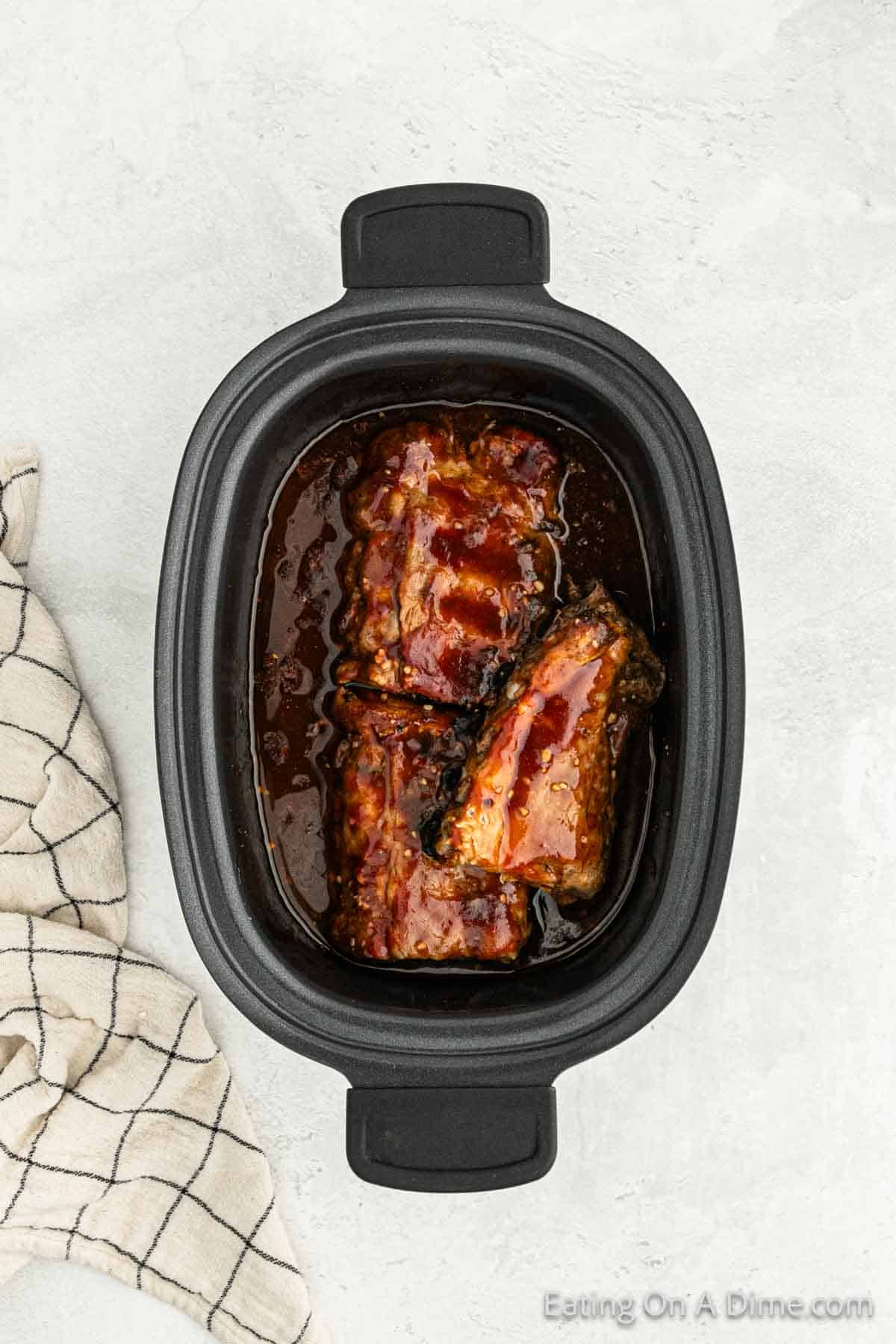 Cooked ribs in sauce in the slow cooker