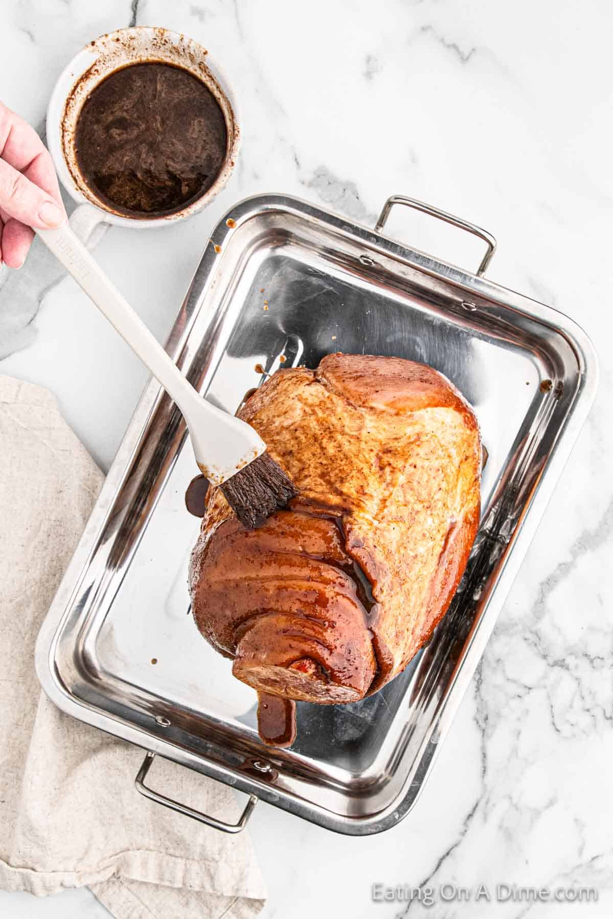 Basting the ham on a roasting pan