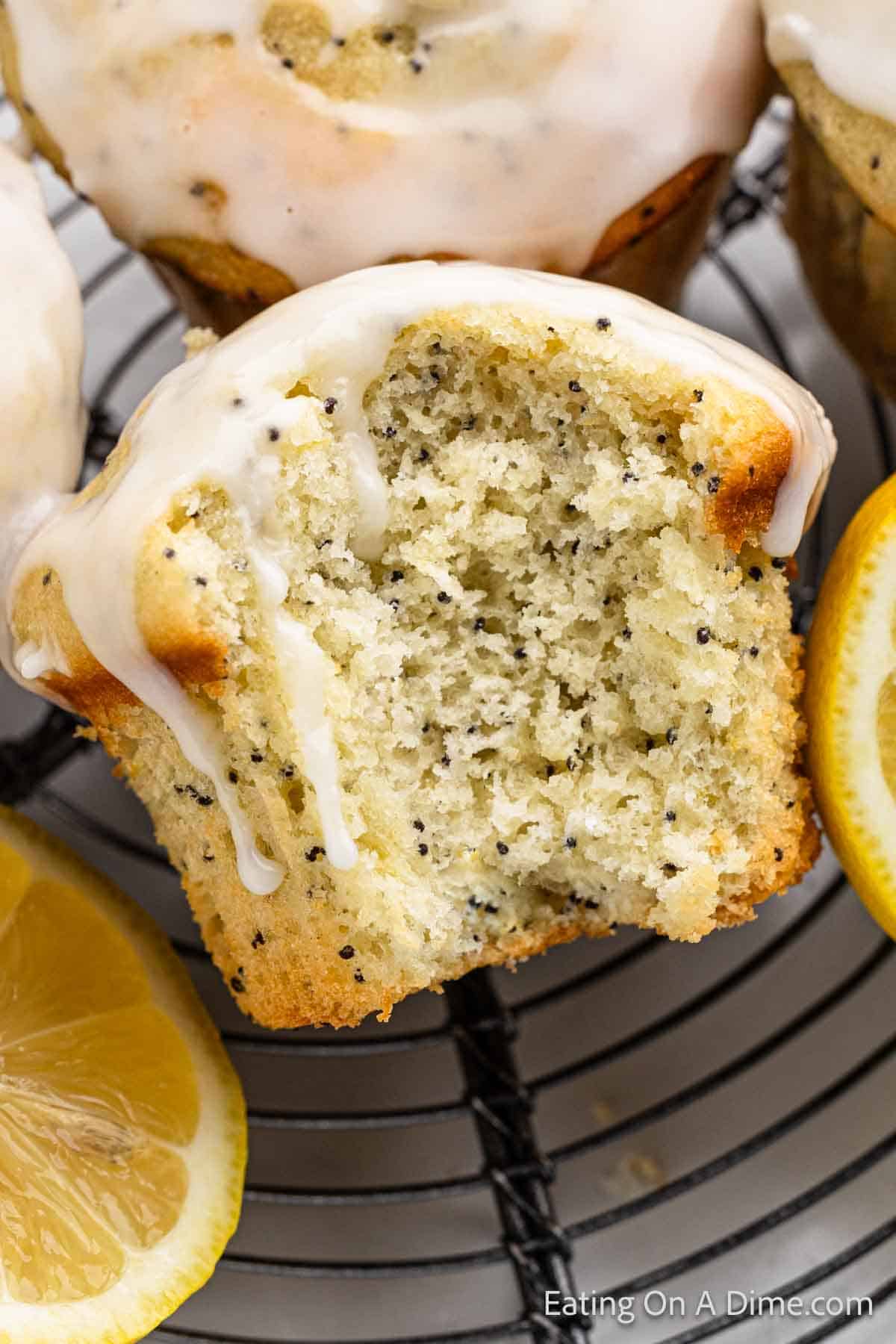 Lemon poppyseeds muffins topped with glaze on a wire rack