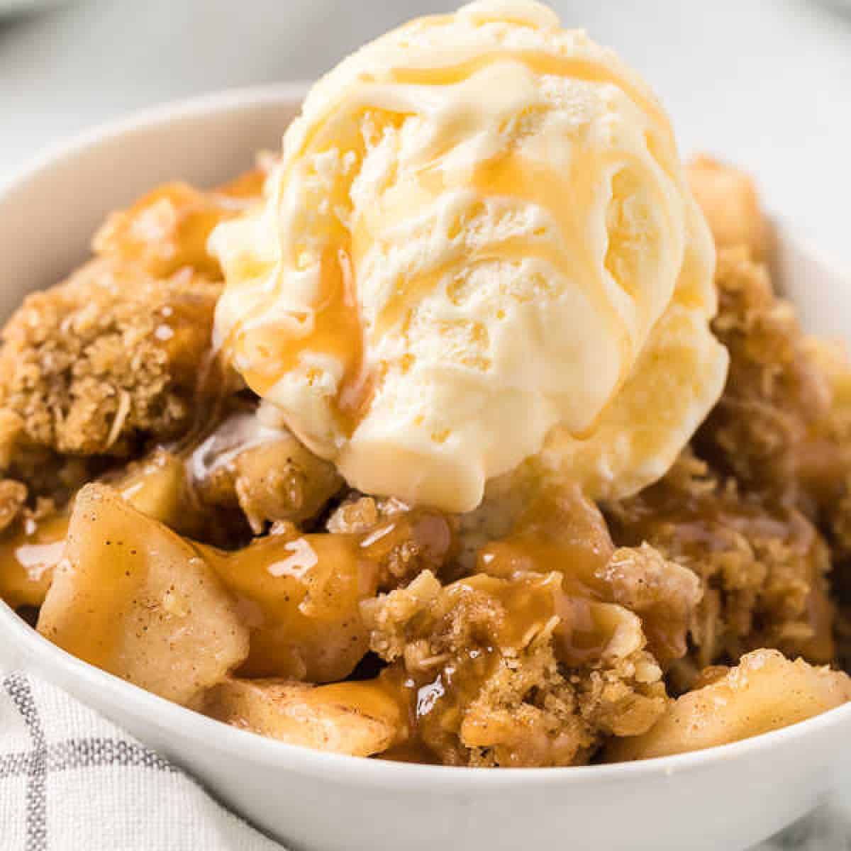 bowl of apple crisp with ice cream and caramel