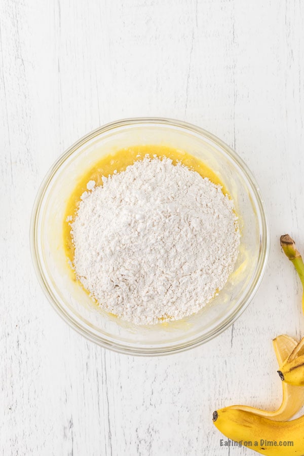 Flour added to the banana mixture in a bowl