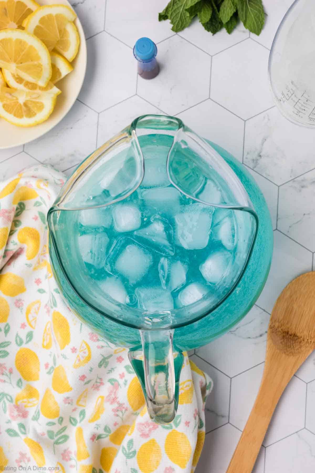 blue lemonade in a glass pitcher with ice