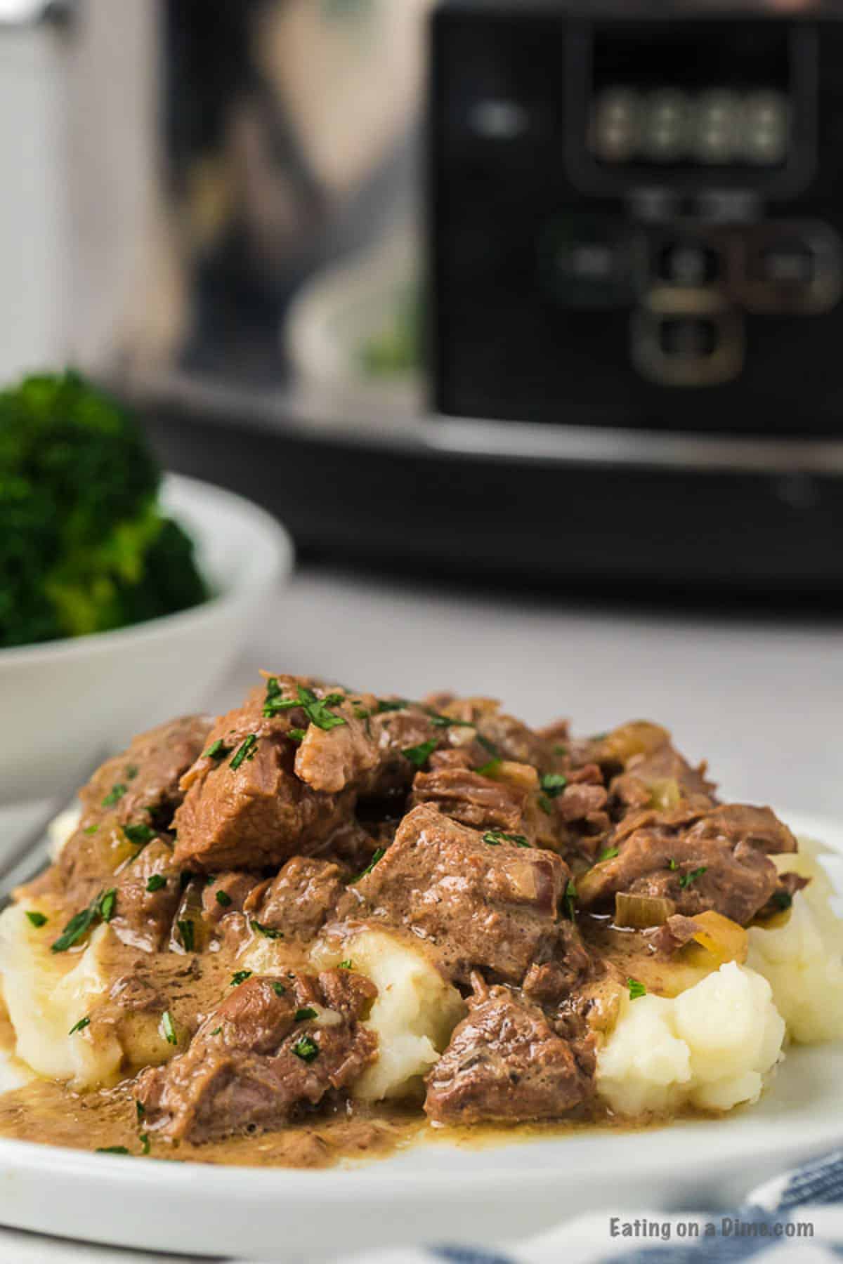 Beef Tips and gravy over mashed potatoes on a plate