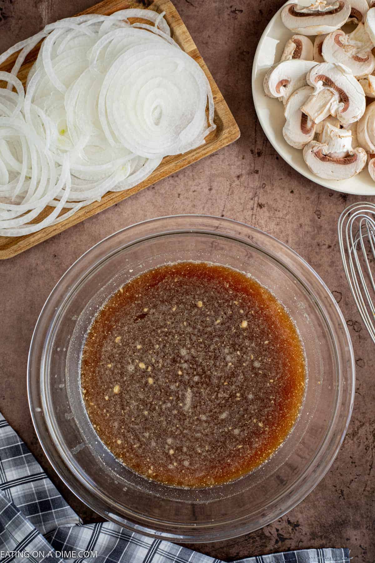 Combining the brown gravy mix, beef broth, Worcestershire Sauce and Dijon Mustard in a bowl