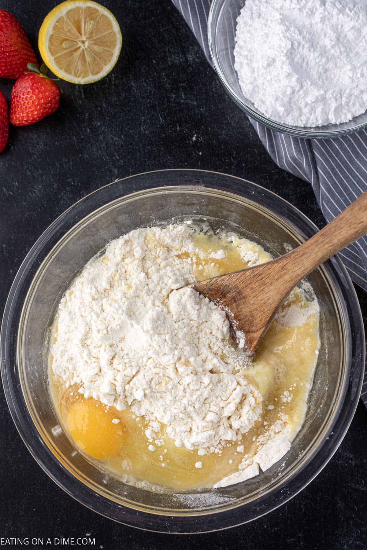 Combining the lemon cake mix with egg in a bowl with a wooden spoon
