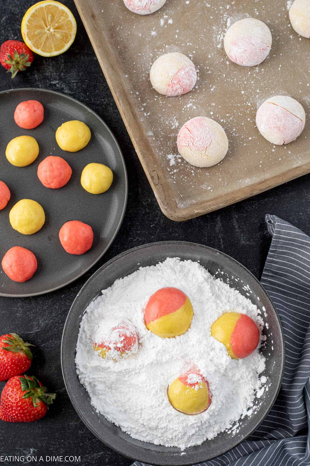 Rolling strawberry cookie dough and lemon cookie dough in a ball and rolling into powdered sugar in a bowl