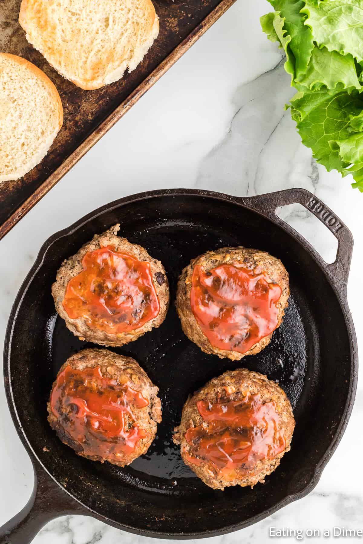 Cooked meatloaf burgers topped with sauce