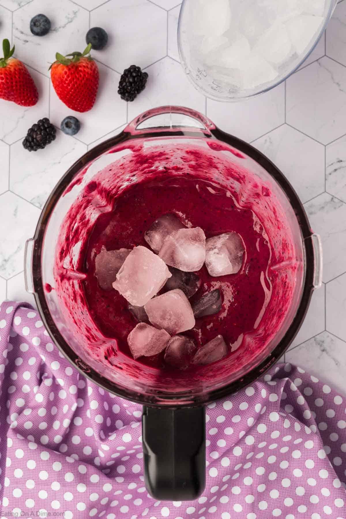 Blended mixed berries topped with ice in a blender