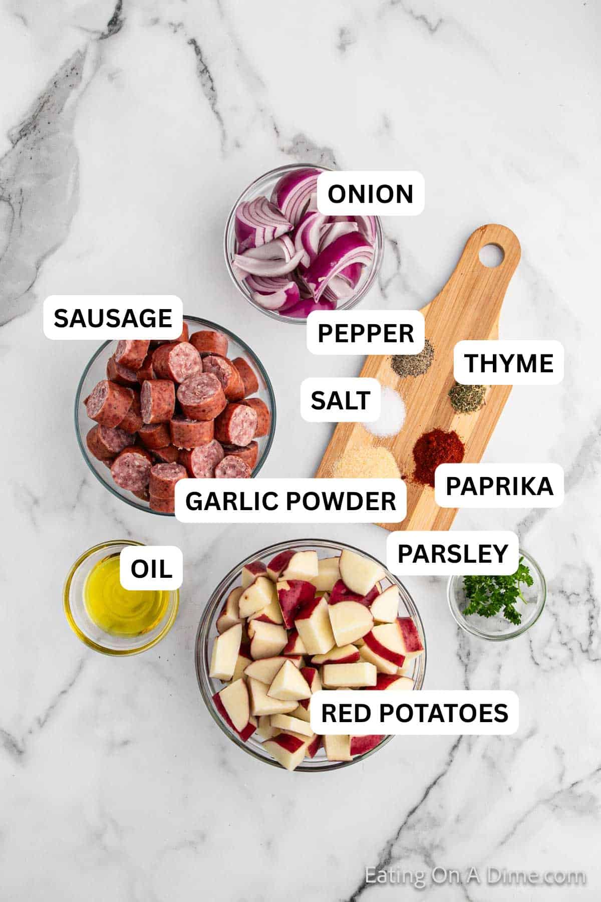 Ingredients needed to make this recipe which includes sausage, red potatoes, onion, spices and oil.