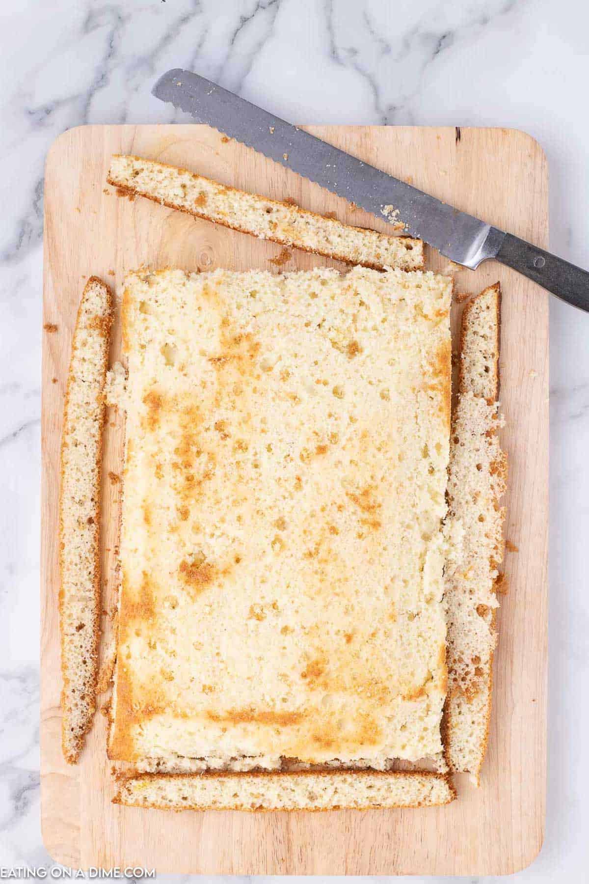 Trimming the bake cake on a cutting board with a knife