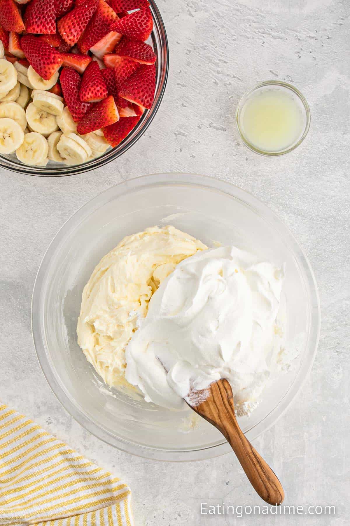 Cool whip topped the cream cheese mixture with fresh strawberries and slice banana on the side with small bowl of lemon juice on the side