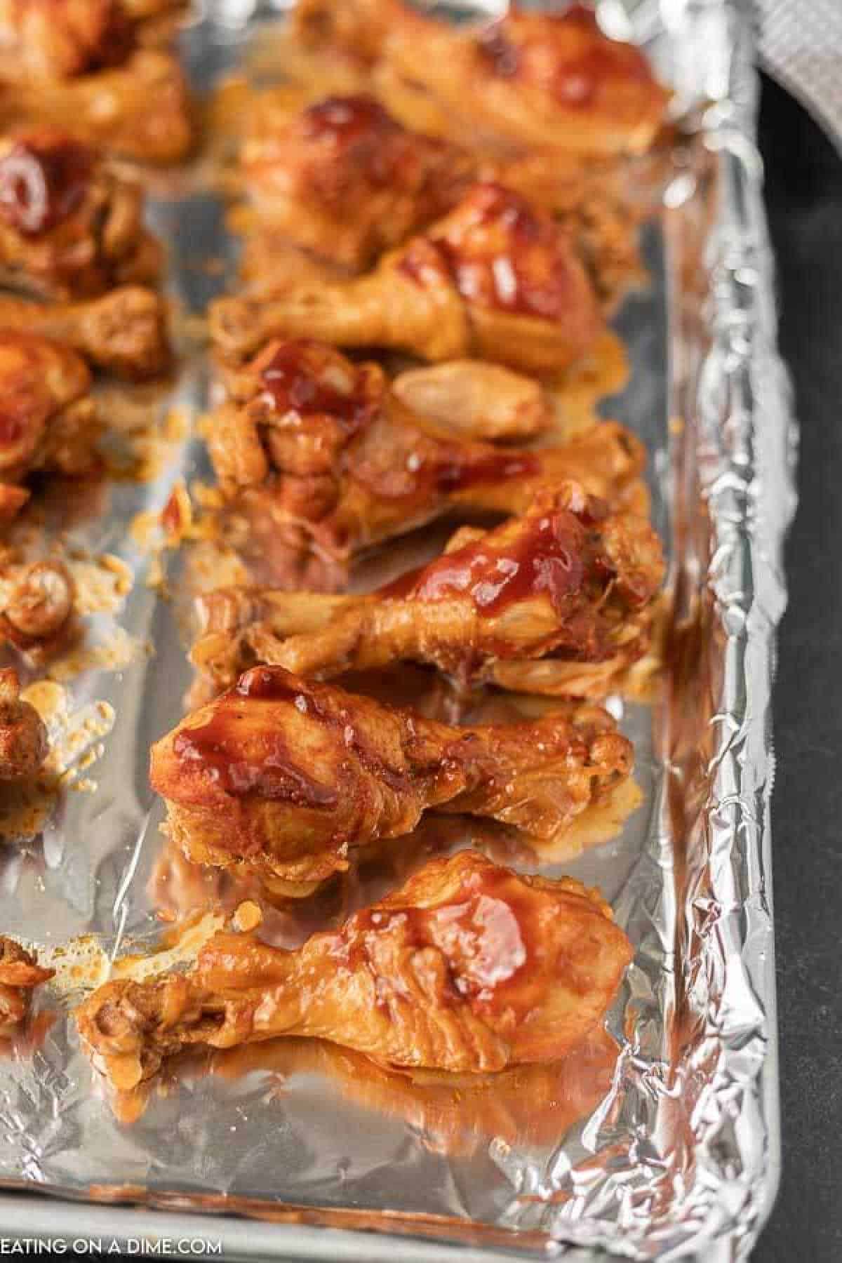 Close up image of drumsticks on a foil lined cookie sheet. 
