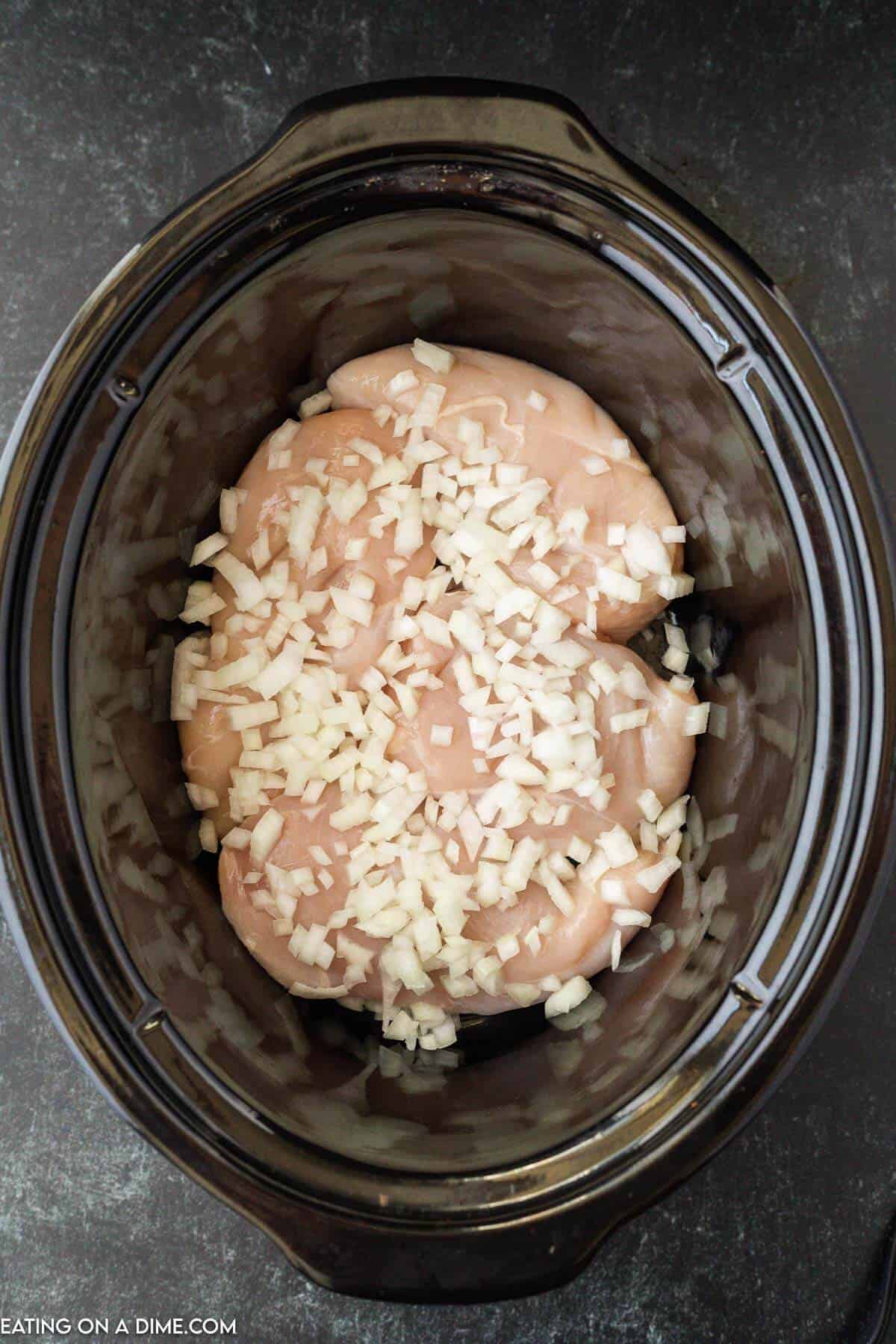 Place chicken in the slow cooker topped with chopped onions