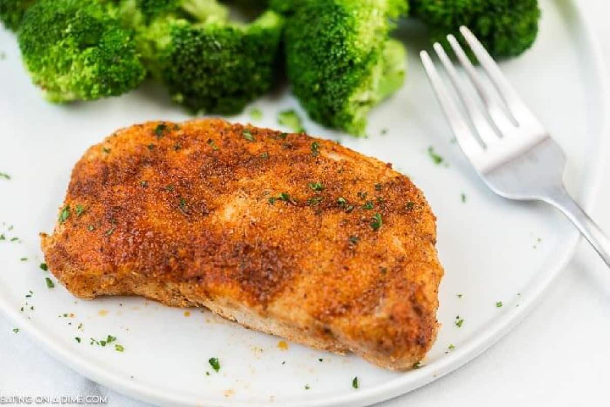 baked pork chops on white plate with broccoli 