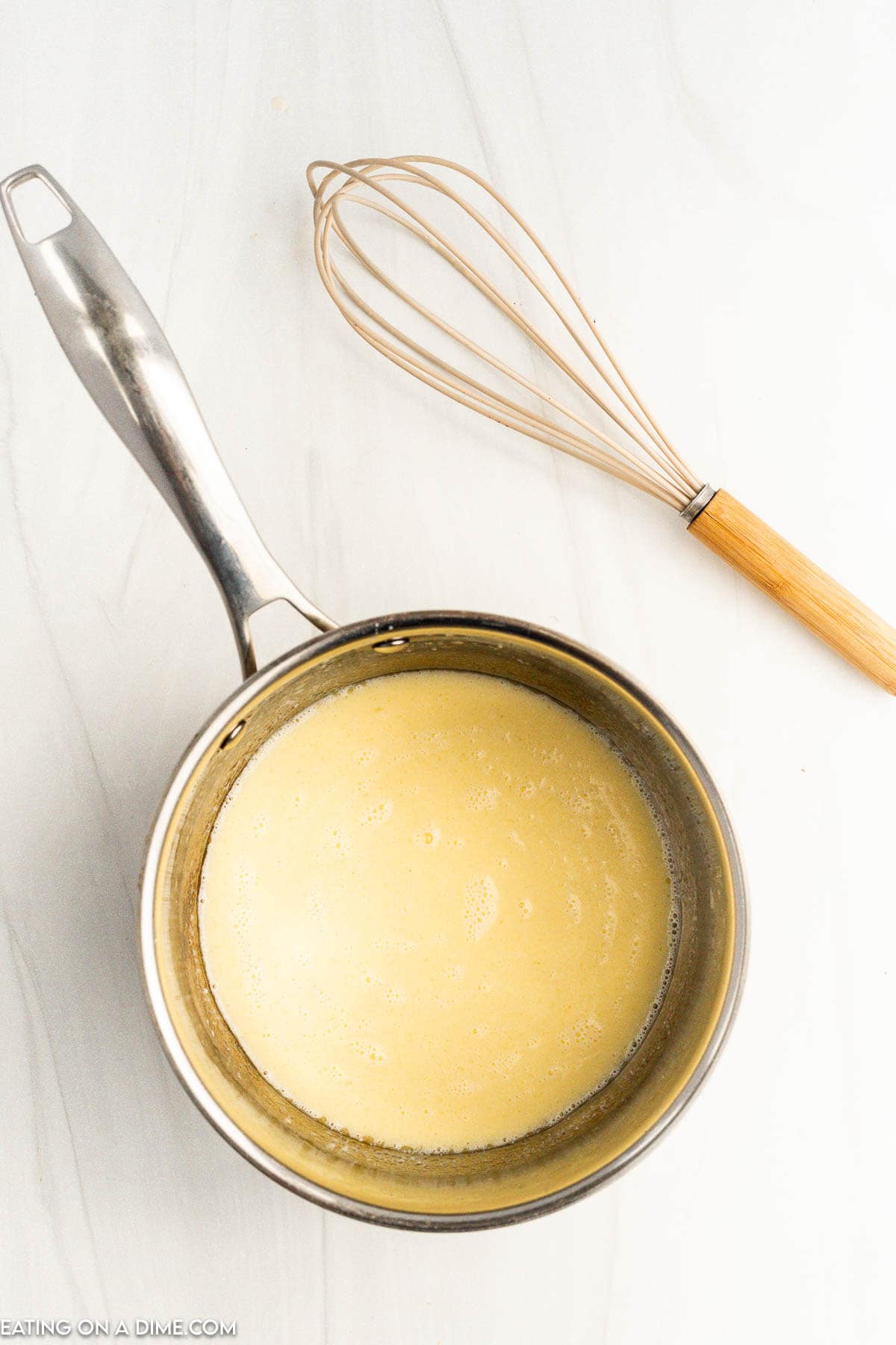 Stirring in half and half in the sauce pan of melted butter