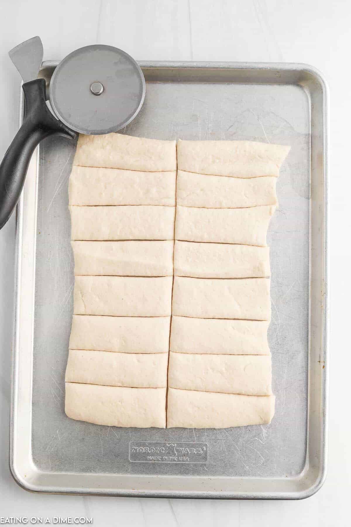 Slice the pizza dough with a pizza crust on a baking sheet