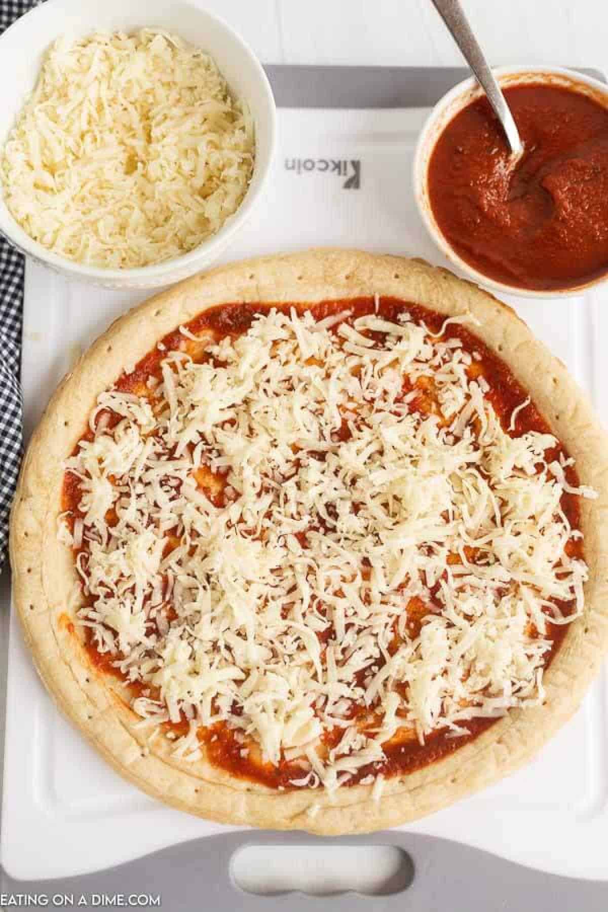 Topping pizza crust and sauce with shredded cheese