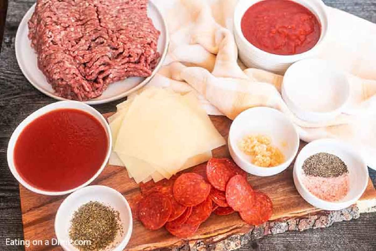 Pepperoni pizza sloppy joes ingredients - ground beef, slice cheese, pepperoni, seasoning, minced garlic, crushed tomatoes