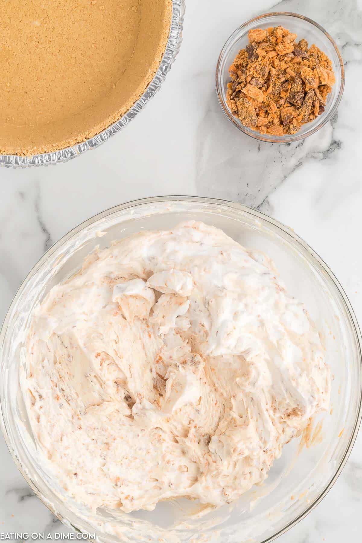 Stir in whipped topping to the peanut butter mixture with a bowl of crushed butterfinger and graham cracker crust