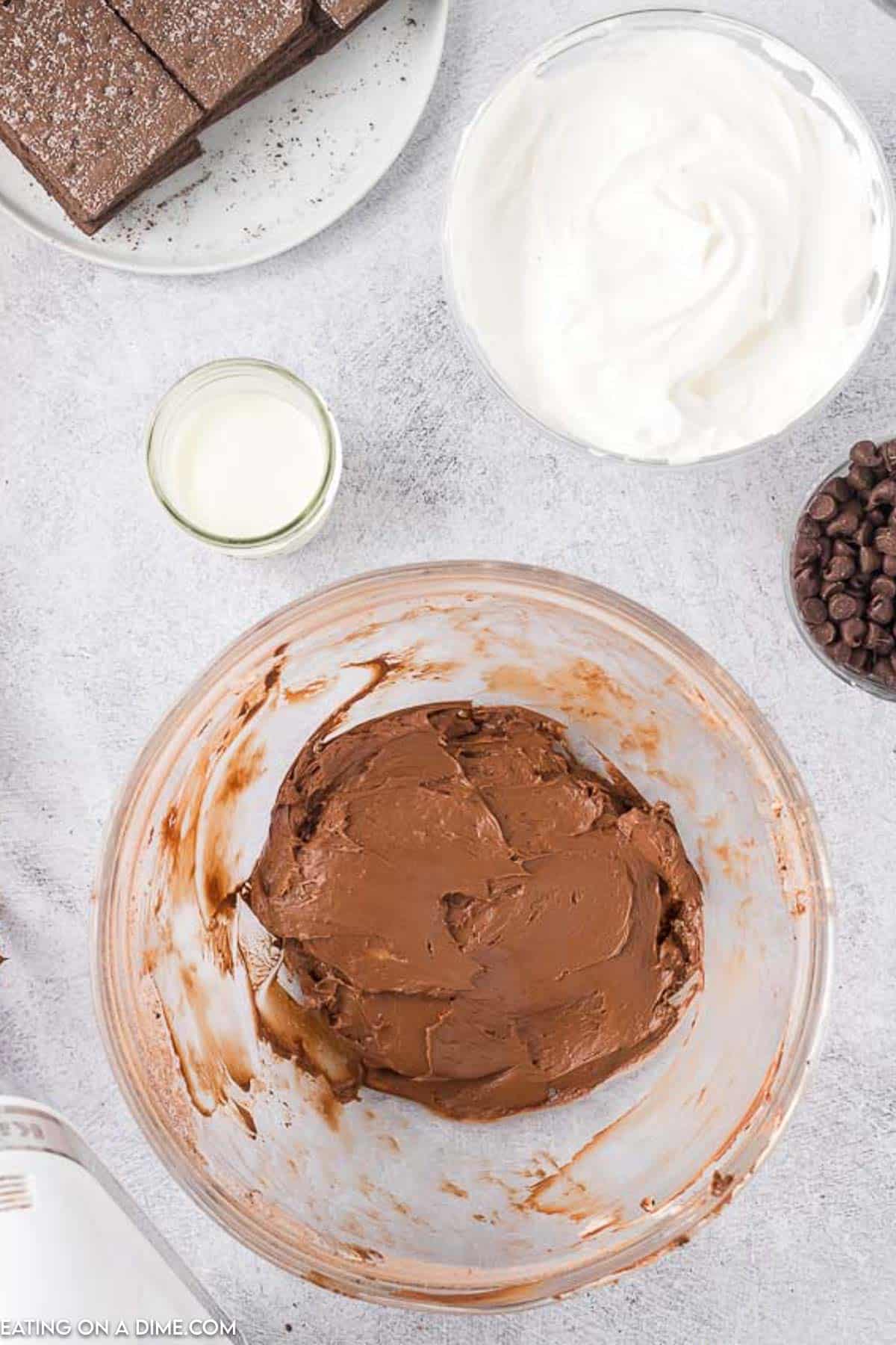 Chocolate mixture in a bowl with a side of cool whip chocolate chips and milk