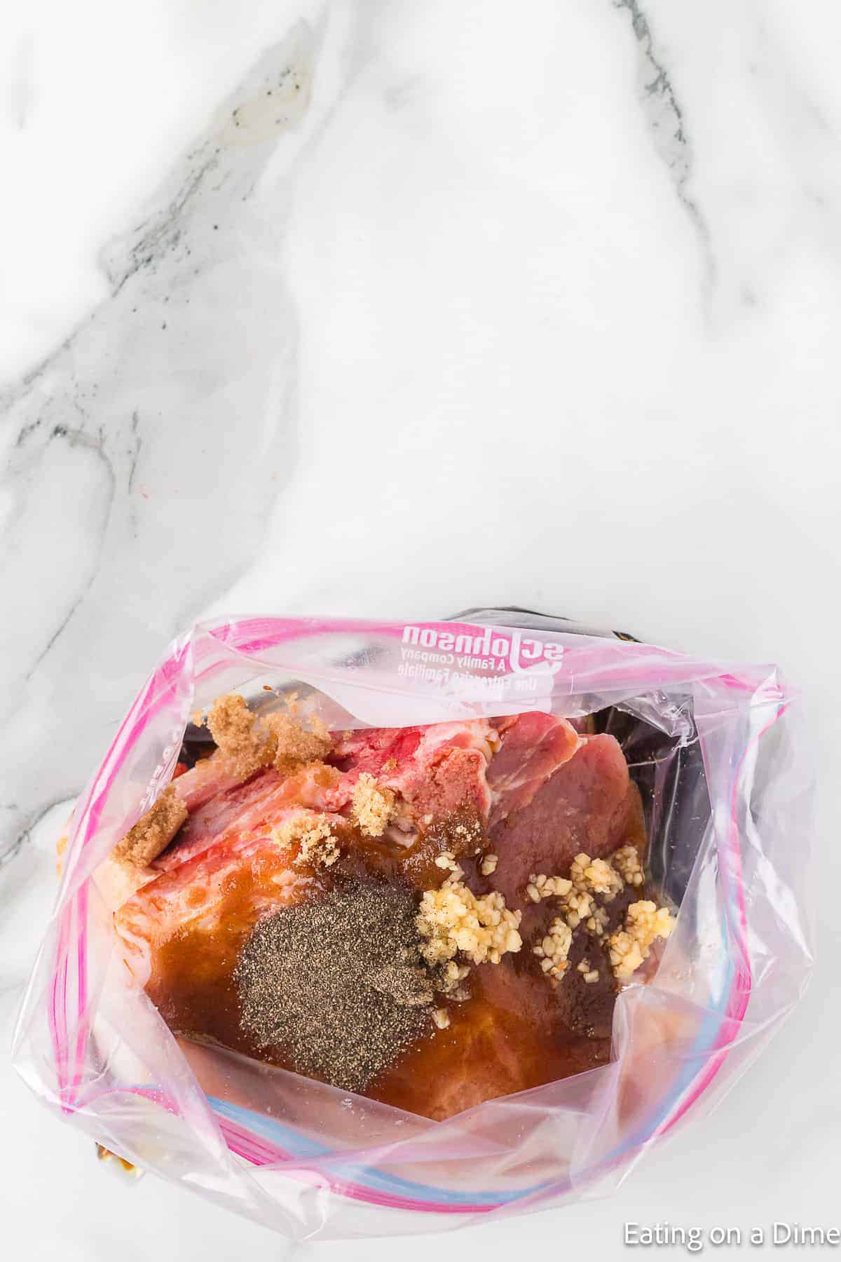 Placing pork chops in a ziplock bag and marinade