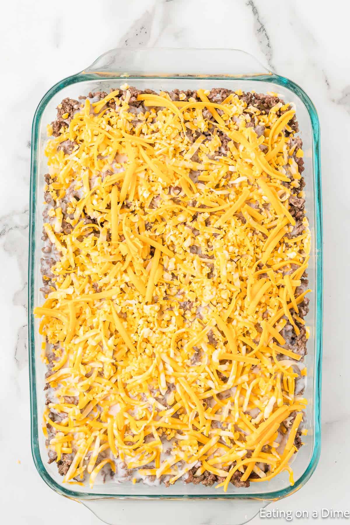 Hamburger Potato casserole in a baking dish topped with shredded cheese
