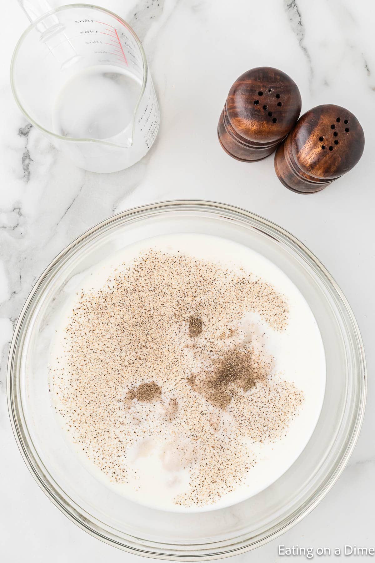 Combining the mushroom soup, milk, salt, and pepper in a bowl