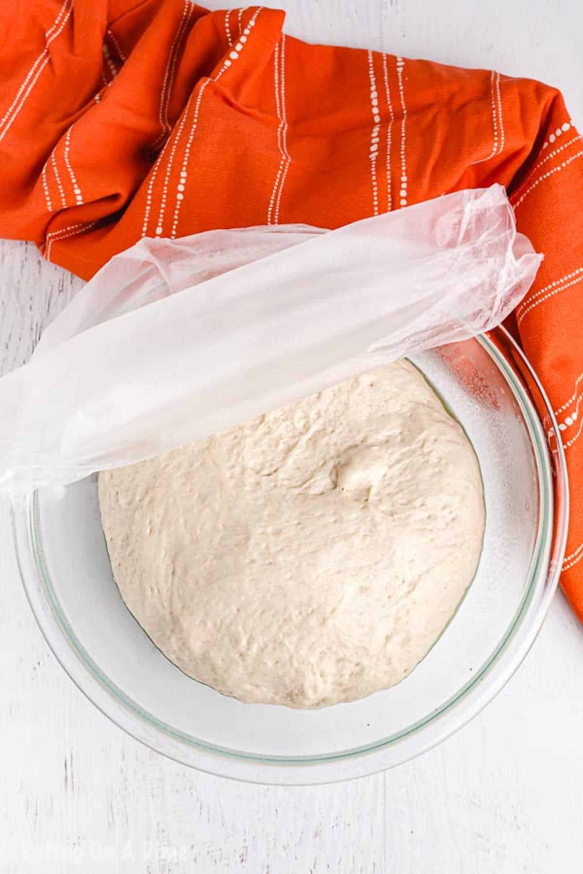 Close up image of dough in a glass bowl. 