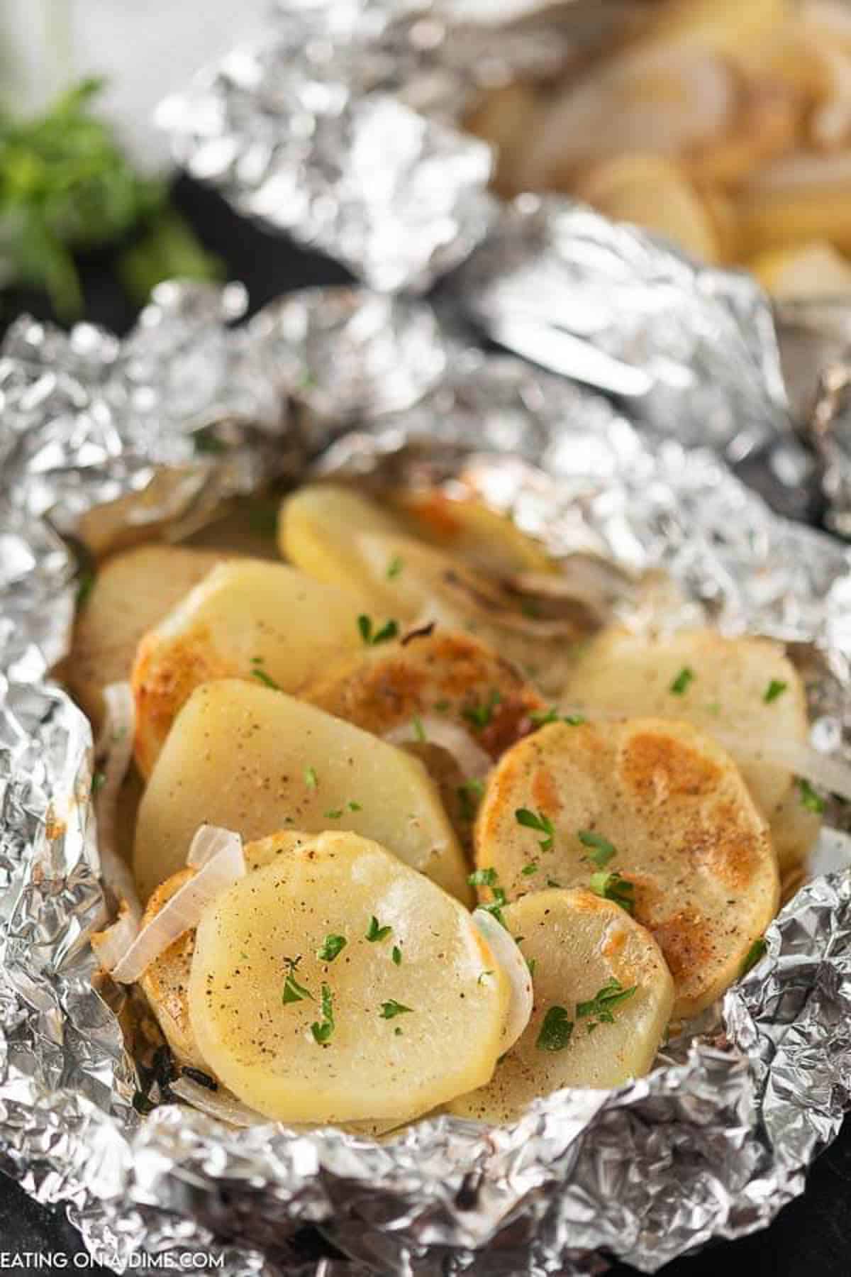 Learn to make grilled potatoes in foil in oven or on grill. These hobo foil potatoes with onions and butter recipe is perfect for camping or to make packets for the oven. I love foil potatoes in oven or foil potatoes on grill because they taste delicious and have an easy clean up! Potato packet for the grill are delicious and perfect for your favorite grilling recipes. #eatingonadime #foilpotatoes #grillingrecipes #grilledpotatoes Grilled potatoes in foil
