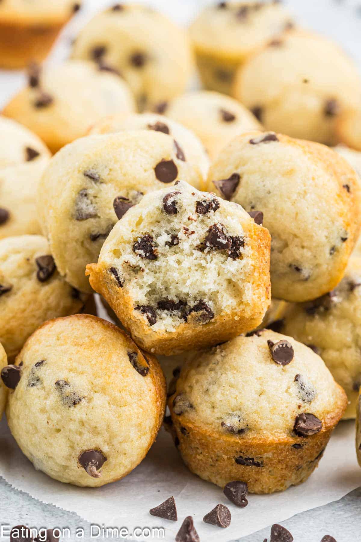 Enjoy Chocolate chip mini muffins recipe for breakfast or a delicious snack. Lots of ooey gooey chocolate make this a tasty treat. Chocolate Chip Mini Muffins stacked on plate