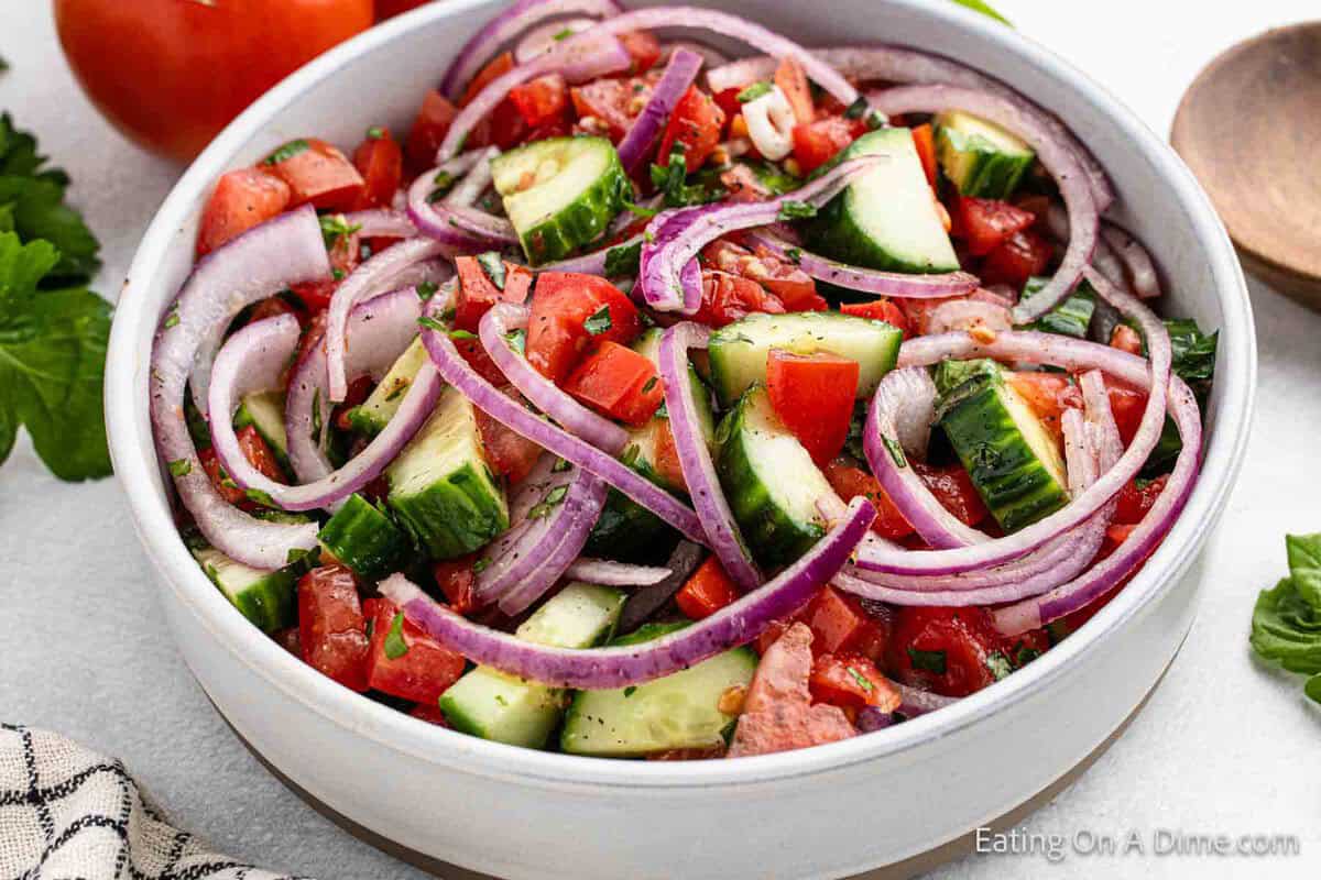 Cucumber and Tomato Salad in a bowl with slice red onions. 