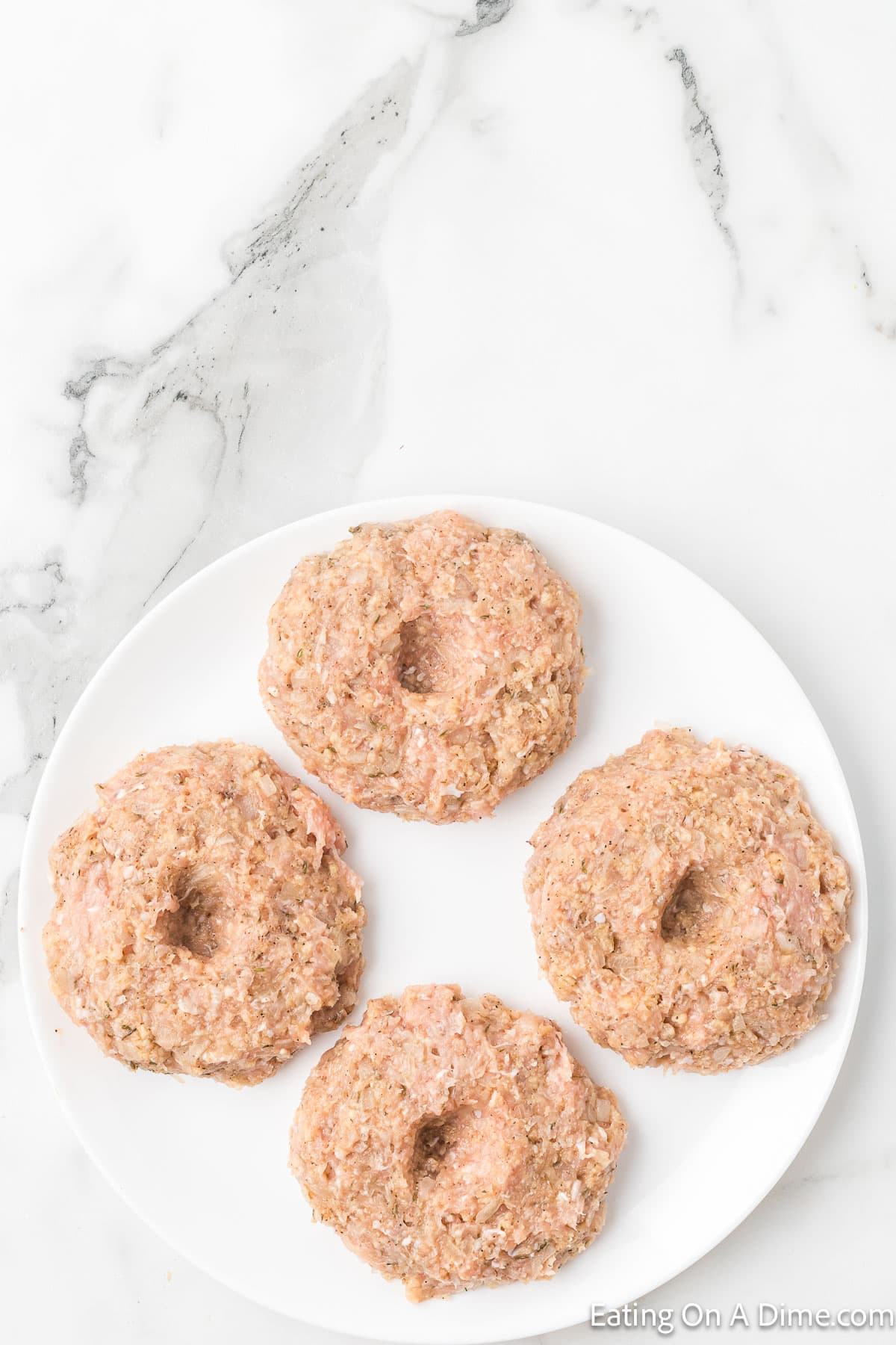Ground Chicken Mixtured shaped into a patty on a plate
