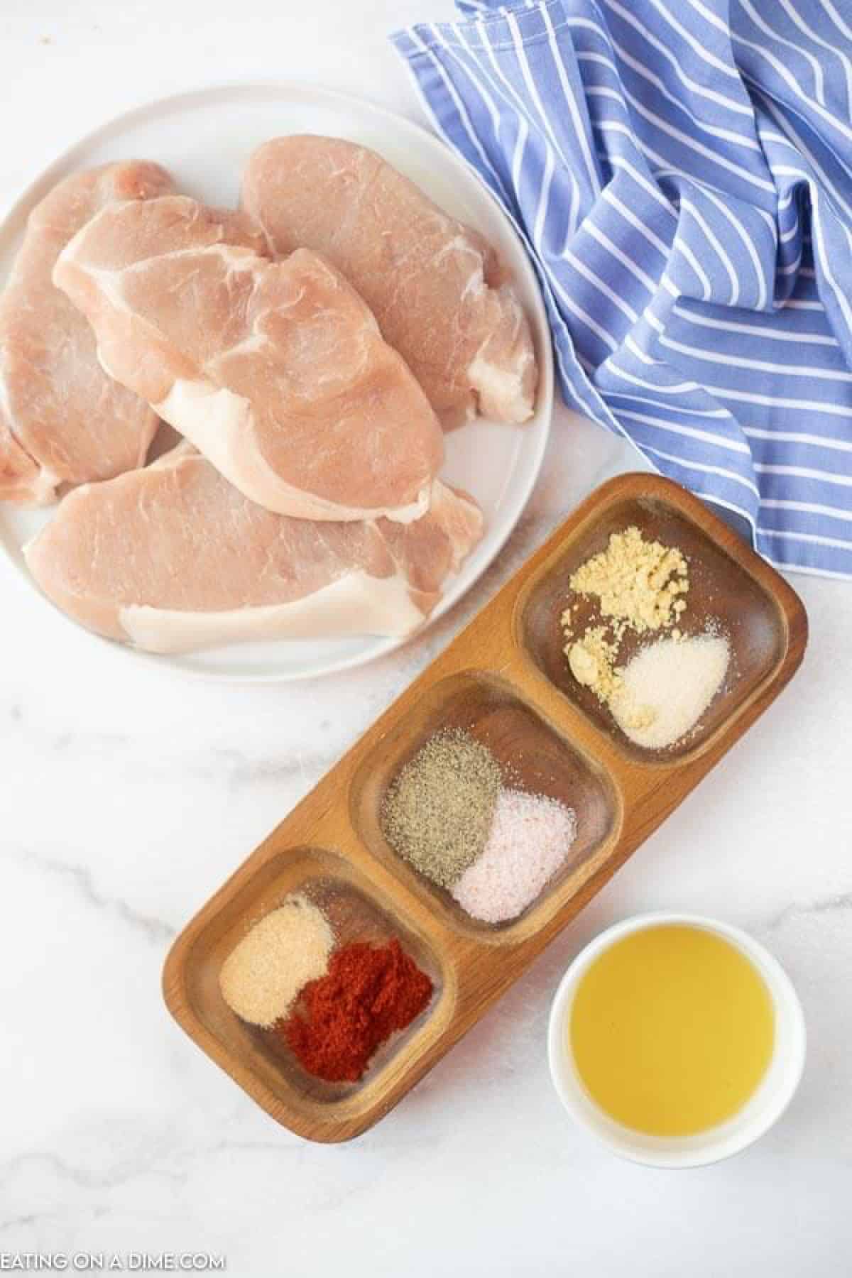 Ingredients needed for air fryer pork chops - pork chops, paprika, salt and pepper, ground mustard, onion powder, garlic powder, olive oil. 