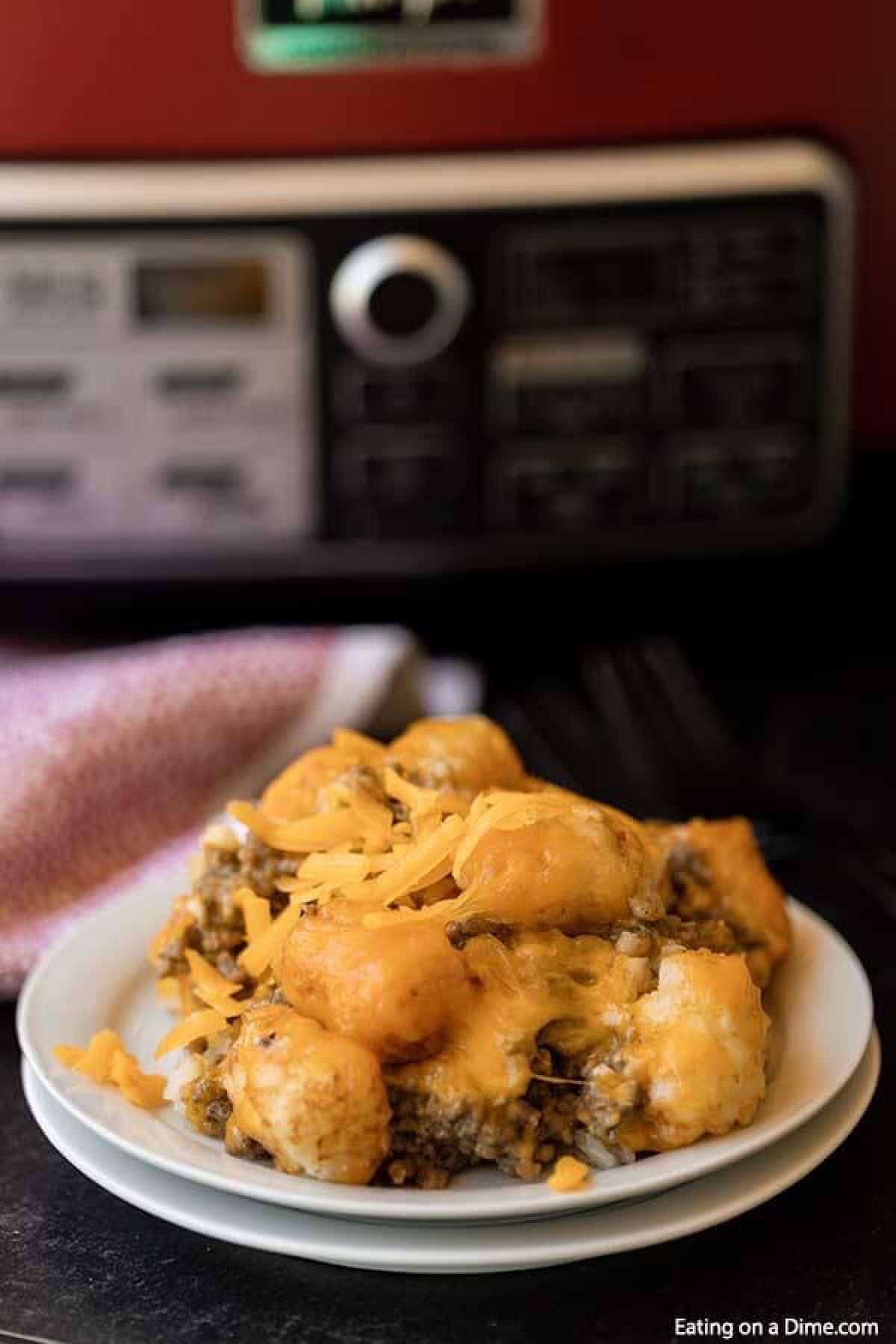 Learn how to make Crock Pot Tator Tot Casserole Recipe. Your slow cooker does all the work and you will come home to Easy Tator Tot Casserole waiting. This simple crockpot tater tot casserole with hamburger and mushroom soup is simple to make and is one of my favorite easy recipes. The entire family will love this cheesy beef tater tot casserole recipe! #eatingonadime #crockpotrecipes #dinnerrecipes #easyrecipes 