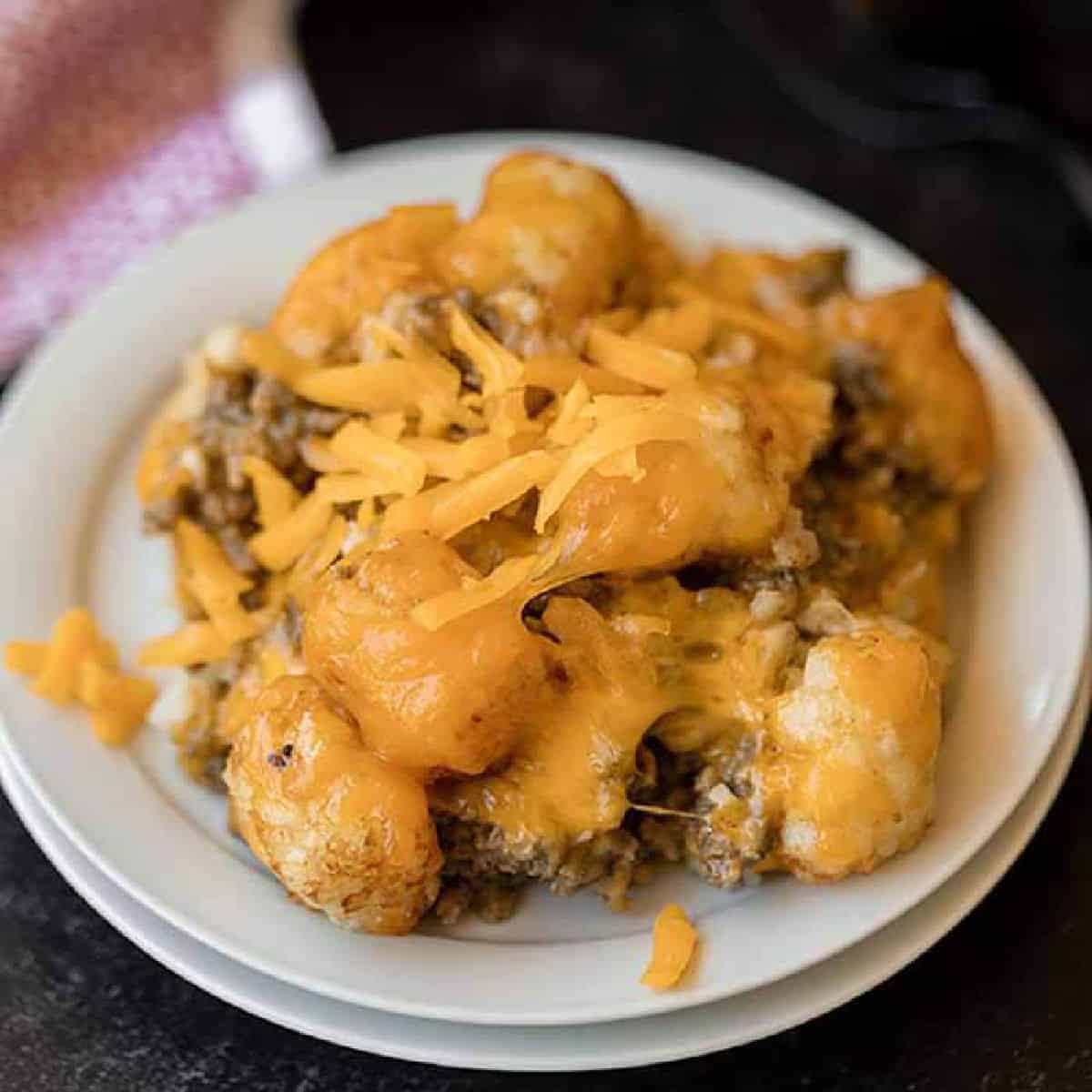 Learn how to make Crock Pot Tator Tot Casserole Recipe. Your slow cooker does all the work and you will come home to Easy Tator Tot Casserole waiting. This simple crockpot tater tot casserole with hamburger and mushroom soup is simple to make and is one of my favorite easy recipes. The entire family will love this cheesy beef tater tot casserole recipe! #eatingonadime #crockpotrecipes #dinnerrecipes #easyrecipes 