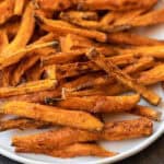 A plate of sweet potato fries with a fork.