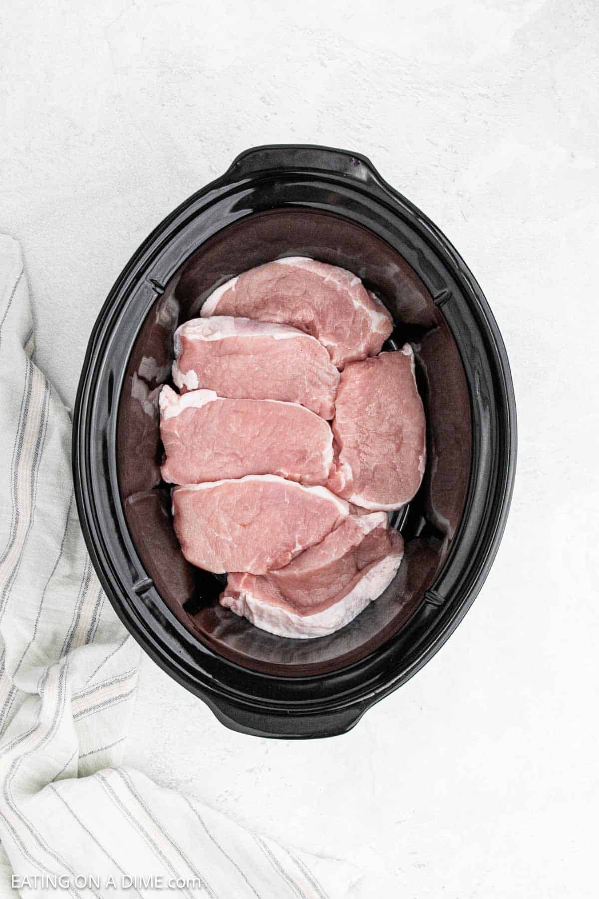 Raw boneless pork chops in the crock pot.
